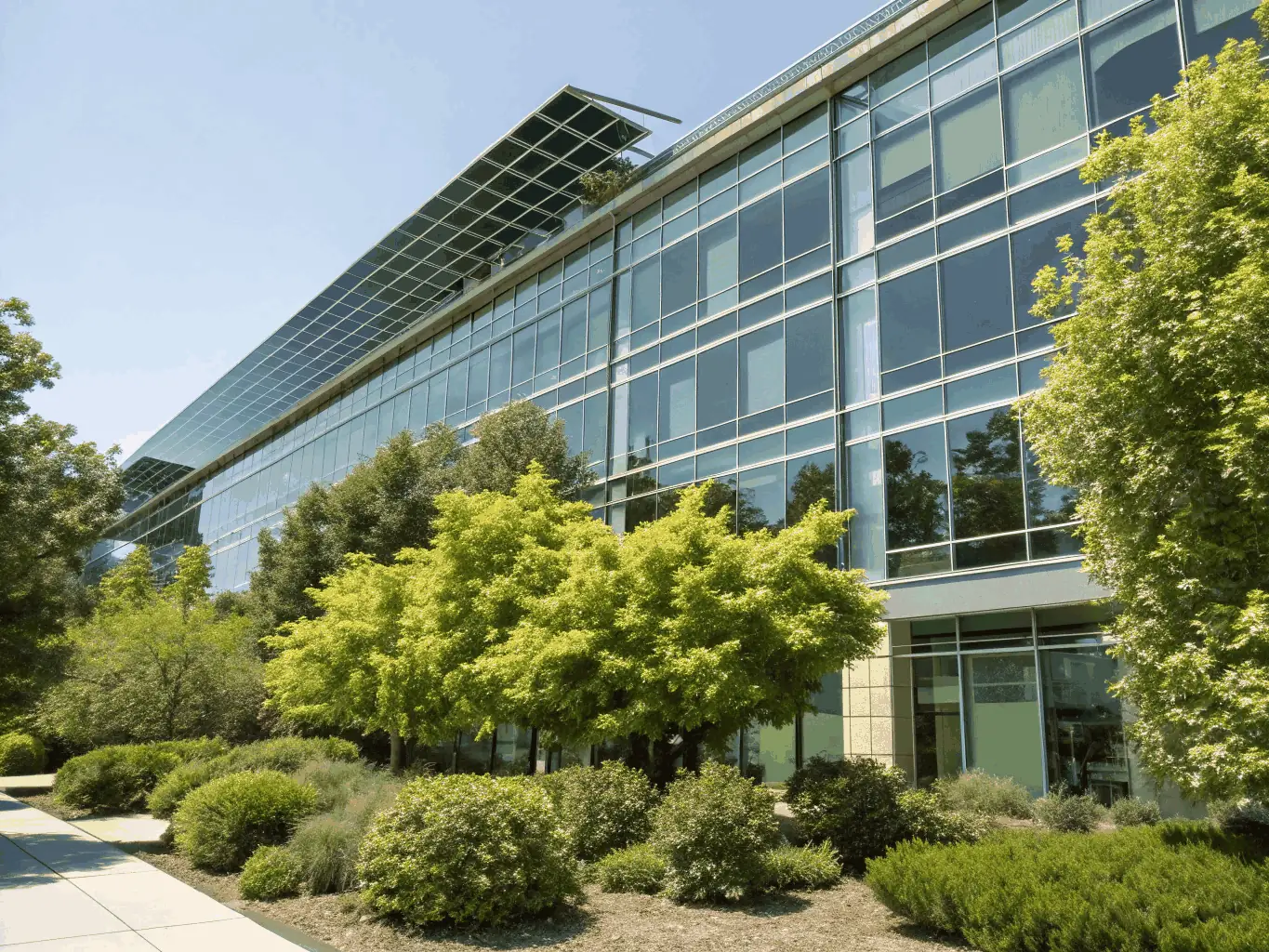 A high-rise building with modern architecture is depicted against a clear blue sky, symbolizing investment opportunities. The building is surrounded by lush greenery, representing sustainable and profitable growth.